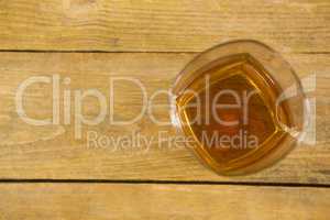 Glass of whisky on wooden table
