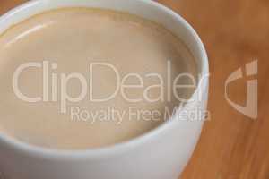 Close-up of white coffee cup with creamy froth