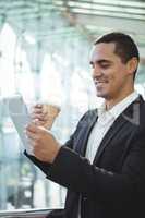 Businessman using digital tablet while having coffee