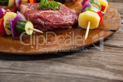 Sirloin chop and skewered vegetables on wooden board