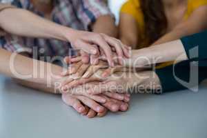 Group of business executives forming hand stack in office