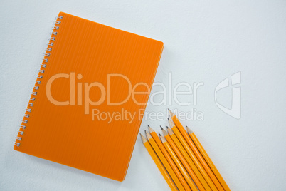 Yellow color pencils with book on white background