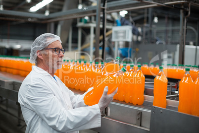 Factory engineer examining a bottle of juice