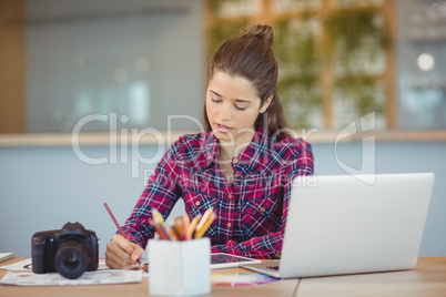 Attentive graphic designer sitting and table and working