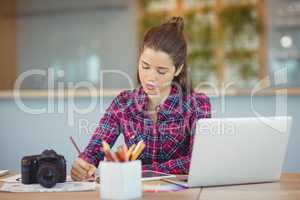 Attentive graphic designer sitting and table and working