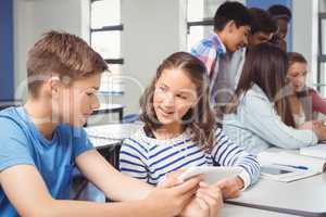 Students using digital tablet in classroom