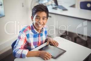Schoolboy with digital tablet at desk