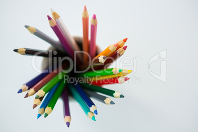 Colored pencils kept in mug on white background