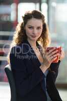 Businesswoman drinking cup of coffee in office
