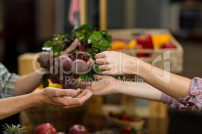 Woman buying beetroot from vendor in the grocery store