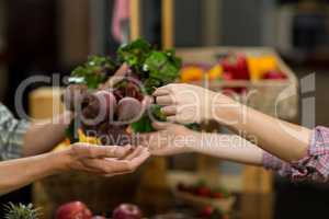 Woman buying beetroot from vendor in the grocery store