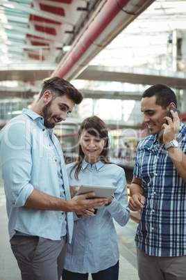 Executives discussing over digital tablet on platform