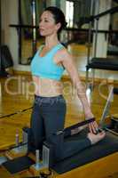 Woman performing stretching exercise on reformer
