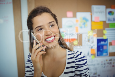 Female executive talking on mobile phone in office