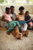 Parents and kids sitting together on sofa with photo album