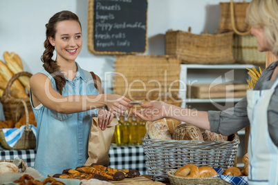 Female staff receiving a payment from customer at counter