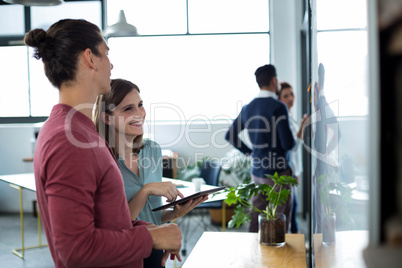 Business executives discussing over digital tablet in office
