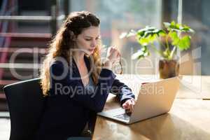 Female business executive using laptop at desk