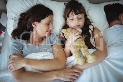 Mother and daughter sleeping in bed