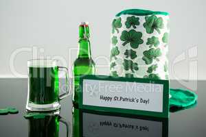 Green beer with shamrock, leprechaun hat and placard of St Patricks Day