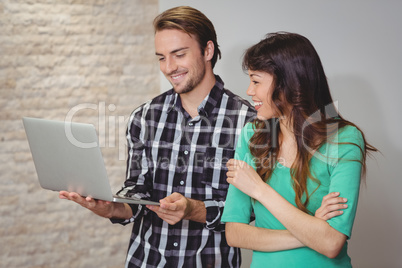 Male and graphic designers discussing over laptop
