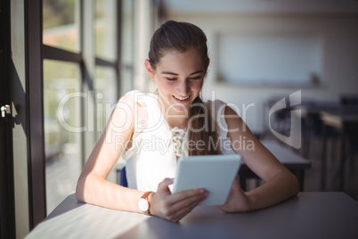 Schoolgirl using digital tablet in classroom