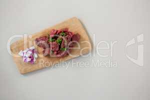 Minced beef and chopped onions on wooden tray