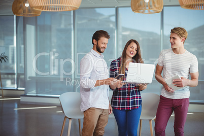 Happy executives using digital tablet and laptop