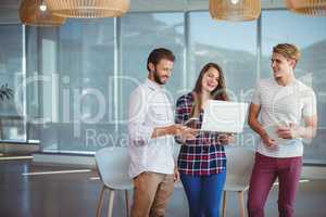 Happy executives using digital tablet and laptop