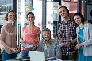 Portrait of smiling business executives with document and digital tablet