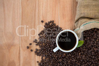 Coffee cup with coffee beans and coffee leaf