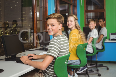 Portrait of smiling students studying in computer classroom