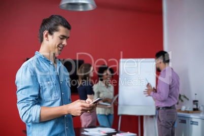 Business executive using mobile phone at meeting