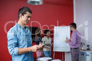 Business executive using mobile phone at meeting