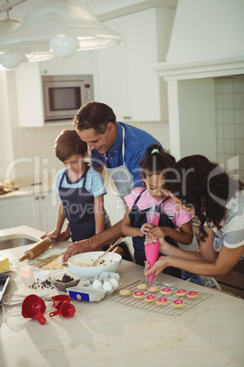 Happy family preparing cookies in kitchen