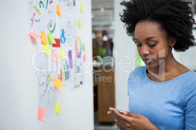 Female graphic designer using mobile phone