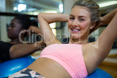 Portrait of smiling woman performing pilate on exercise ball