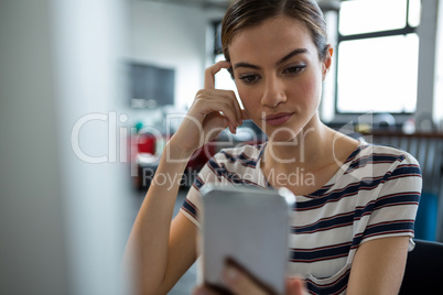 Female graphic designer using mobile phone