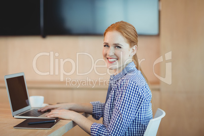 Portrait of female graphic designer using laptop