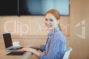 Portrait of female graphic designer using laptop