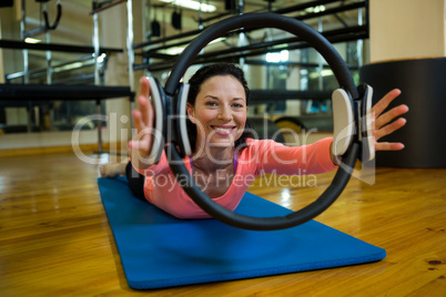 Portrait of happy woman exercising with pilates ring