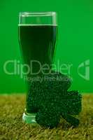 Glass of green beer and shamrock for St Patricks Day on grass