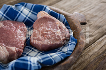 Sirloin chop on wooden tray against wooden background