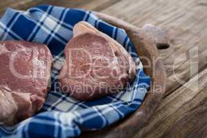 Sirloin chop on wooden tray against wooden background