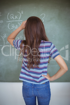 Rear view of schoolgirl pretending to be a teacher in classroom