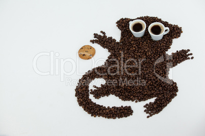 Coffee beans and cups forming monkey with cookie