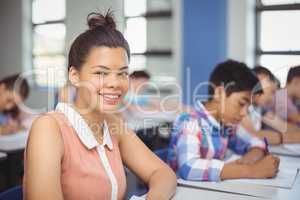 Schoolgirl sitting at desk in classroom