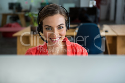 Portrait of female executive with headphones at creative office