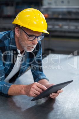 Factory worker using a digital tablet in factory