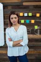 Business executive standing with arms crossed in office